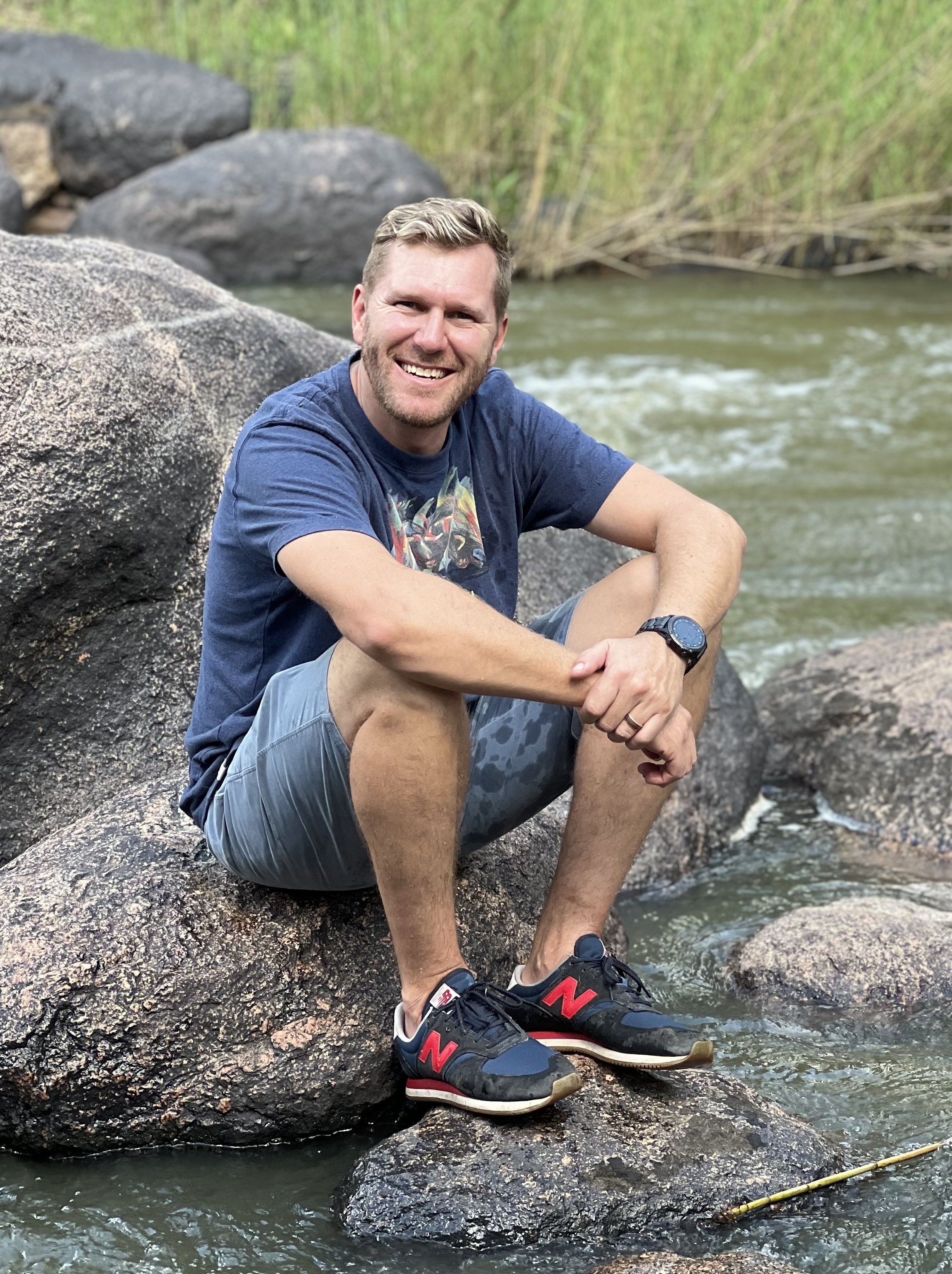 Young man with dark hair and beard, brown eyes, blue t-shirt